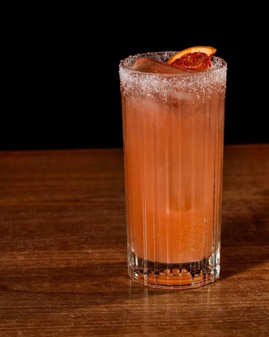 Cóctel Paloma Bloody de tequila y pomelo con borde de sal y pomelo deshidratado